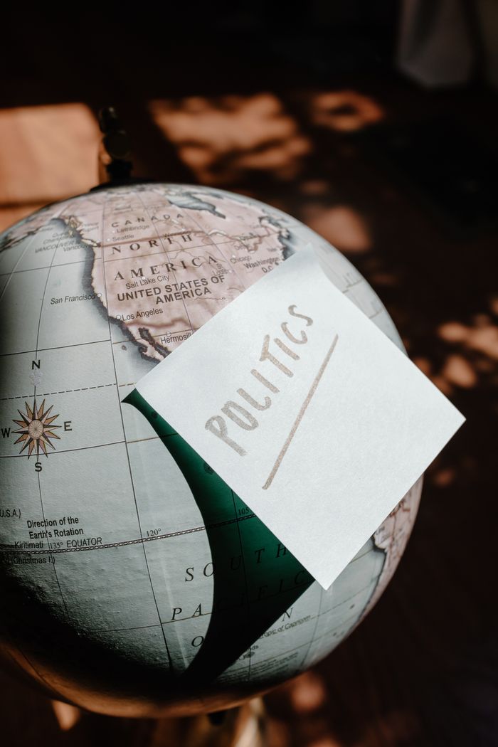 A globe focused on the USA with a sticky note reading Politics.